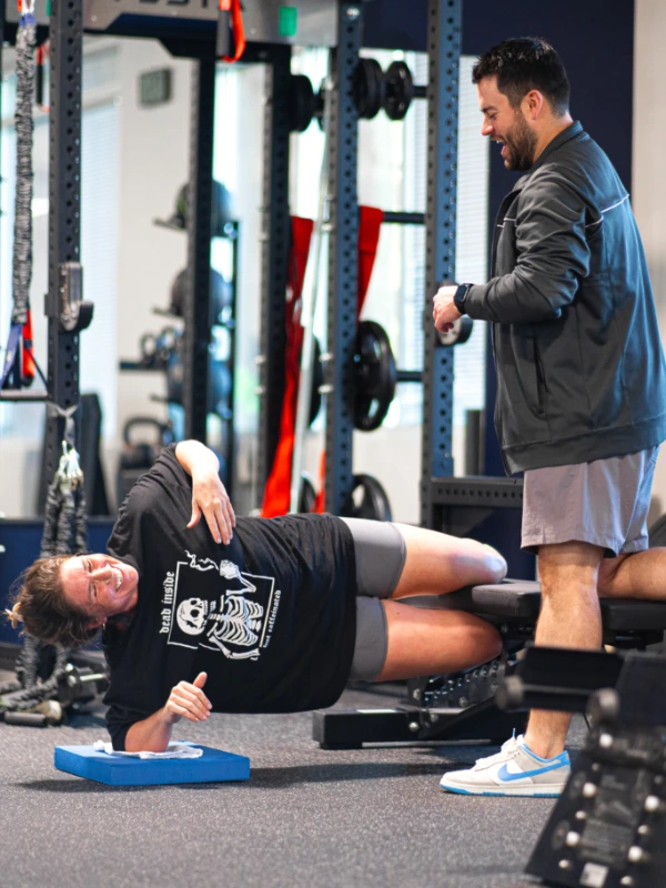 Parker working with a female patient as she does a side plank.