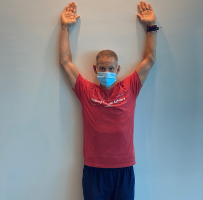 A man demonstrating wall angels step1.