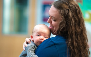 Stephanie Gilboy, PT, DPT holding an infant suffering from torticollis.