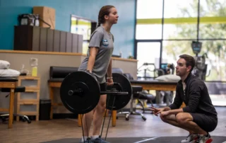 A female athlete performing a deadlift.