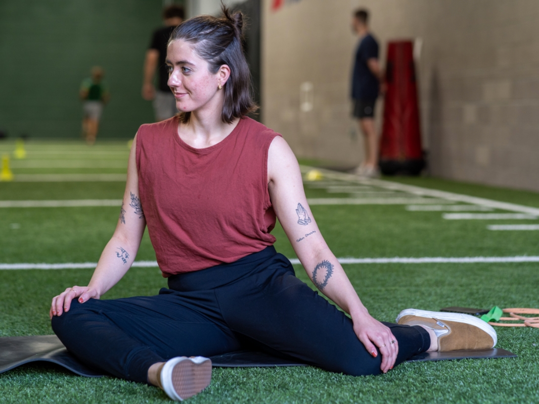 Image of a woman doing the 90/90 exercise in the starting position facing left.