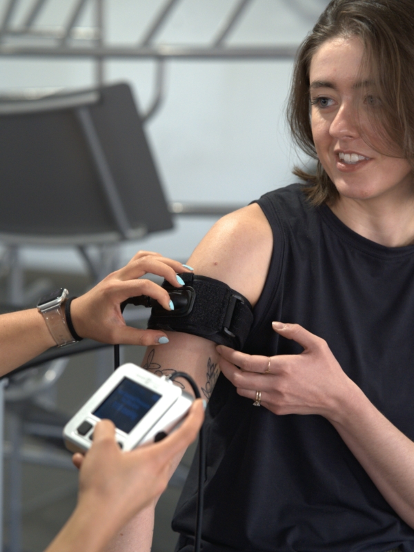 Image of a woman having a BFR cuff fitted to her arm.