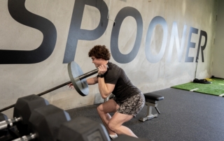 Feature image of a male athlete lifting a corner barbell.