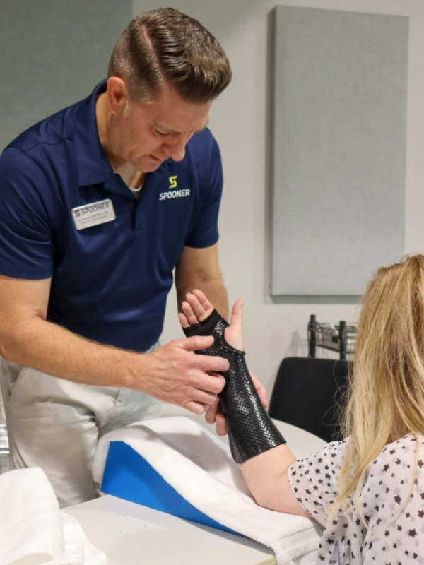 Image of a woman getting fitted for a hand split from a hand therapist.