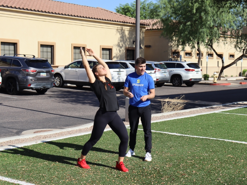 image of woman doing a forward lunge with arms in the air.