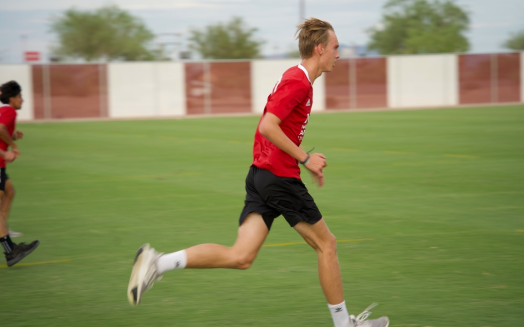 Feature image of a teenager in a red uniform running on a soccer field