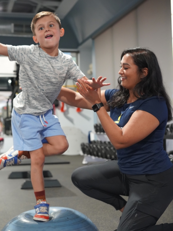 out-Peds-child image Image of a young child standing on one leg on a 1/2 bosu ball.