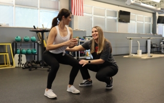 Feature image of a therapist helping a female patient.