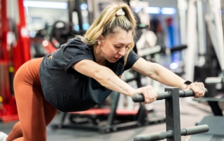 Feature image of Shannon stretching on a training handlebar.