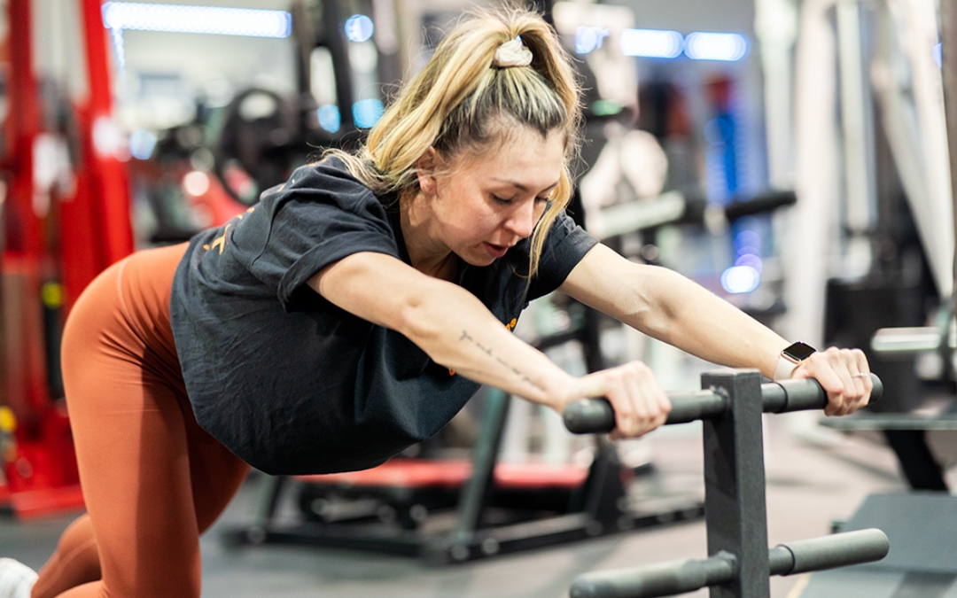 Feature image of Shannon stretching on a training handlebar.