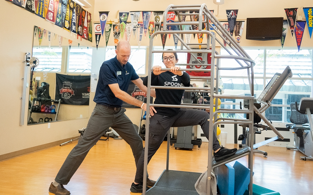 Feature image of a therapist helping a woman use a stretch cage.