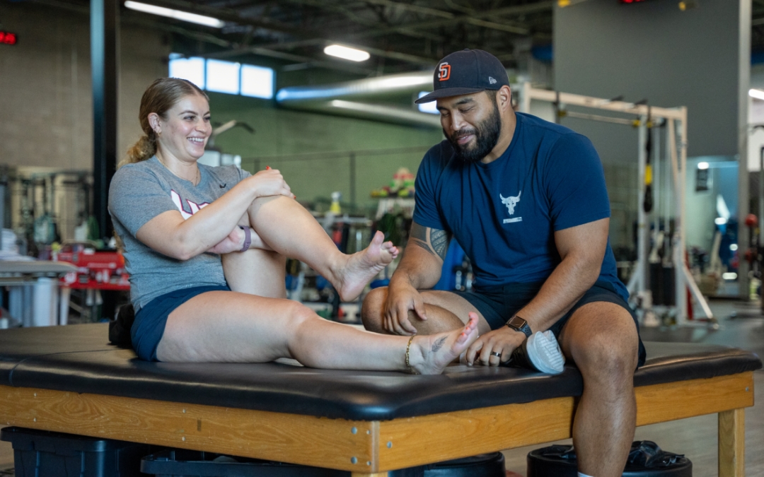 The Big Toe Blog feature image of Charles Dela Cruz examining the foot of a female athlete.