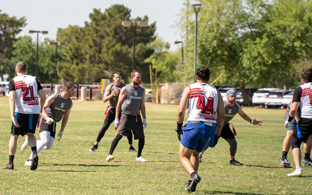 Feature image of a group of men playing flag football.