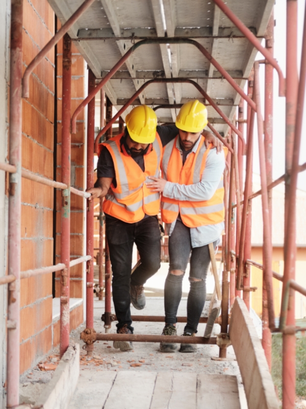 out-Work Injury image Image of one construction worker helping another construction worker after a work injury.
